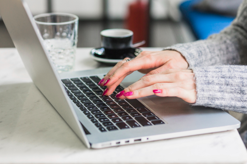 A woman is using a laptop computer to apply for Social Security disability benefits.